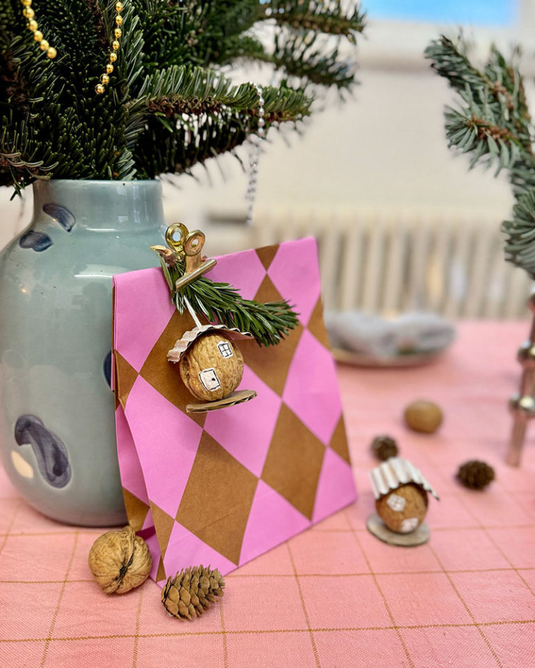 Dióhéj házikó ajándékcsomagra kötve, fenyőággal díszítve