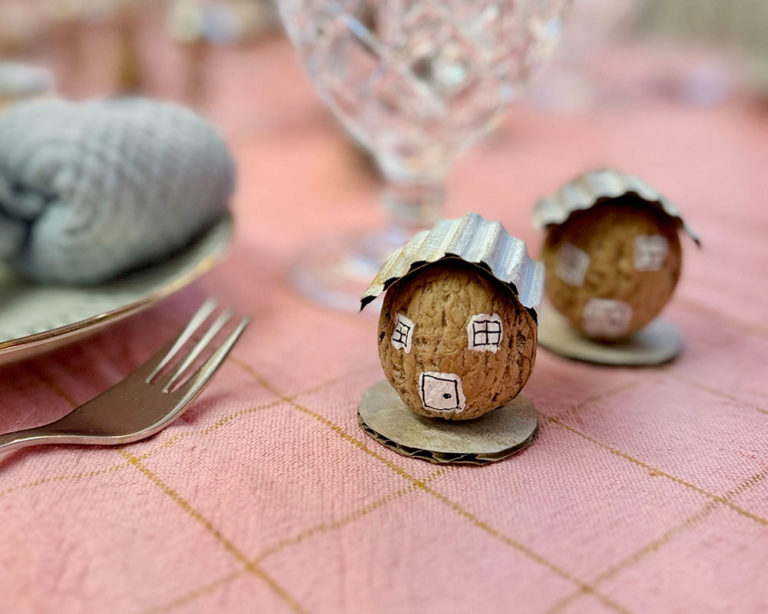 Dióhéj házikó közelről, festett ablakokkal és hullámkarton tetővel